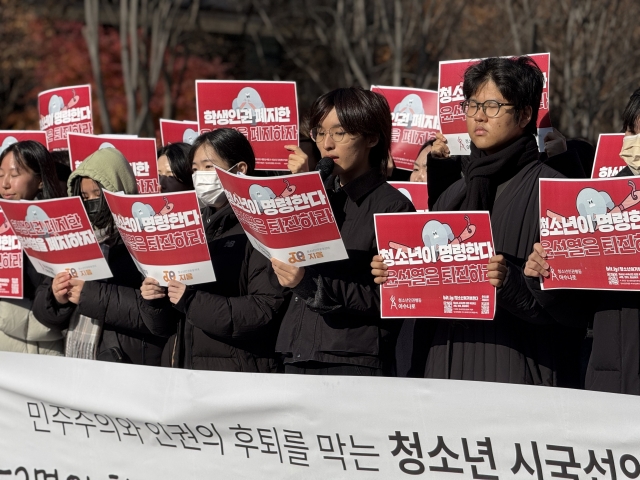 Soo-young (fourth from left), an 18-year-old activist with Asunaro, speaks at Gwanghwamun Square on Tuesday, stating that President Yoon’s policies have “turned our lives upside down” and calling for his resignation. (Moon Joon Hyun/The Korea Herald)