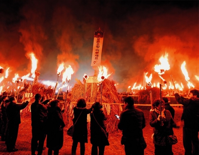 Tourists gather at Saebyeol Oreum to set fire to the field during the Jeju Fire Festival held in March, 2019 (Jeju provincial government)