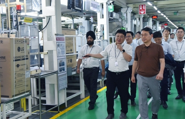 LG Electronics CEO Cho Joo-wan (right) inspects the company's production facility for home appliances in India in June last year. (LG Electronics)