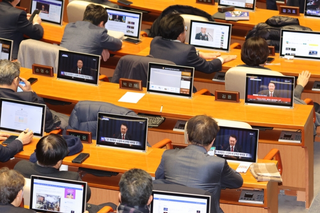 Lawmakers watch President Yoon Suk Yeol deliver address to the nation at around 4:28 a.m. Wednesday at the National Assembly plenary hall. (Yonhap)