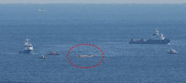 A fishing boat that capsized after colliding with a sand barge is seen in this photo (circled in red), Monday. (Yonhap)