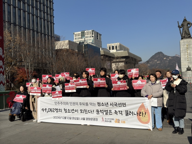 Youth activists gather at Gwanghwamun Square in Seoul on Tuesday, holding a banner reading, “49,052 Youth Voices Demand: Yoon Seok Yeol Must Step Down,” as part of a protest against martial law and threats to democracy. (Moon Joon Hyun/The Korea Herald)