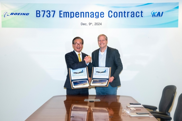 KAI CEO Kang Goo-young (left) and Boeing's Vice President Cory Gionet pose for a photo to celebrate their deal extension at Boeing's headquarter in Seattle, the US, Monday. (KAI)