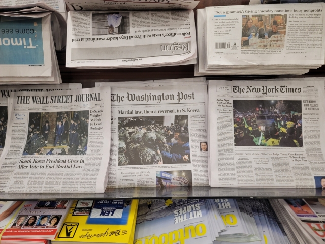 Major US daily newspapers feature South Korean President Yoon Suk Yeol's declaration of martial law on the front pages of their Wednesday editions, displayed at a newsstand in Virginia. (Yonhap)