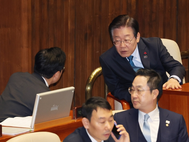 Main opposition leader and Democratic Party of Korea Rep. Lee Jae-myung talks with Democratic Party Floor Leader Park Chan-dae during a parliamentary plenary meeting held at the National Assembly in western Seoul on Tuesday. Yonhap